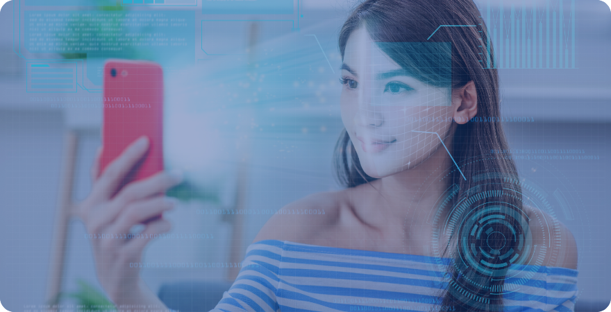 Woman with dark hair smiling at a mobile phone screen whilst she completes ID verification.